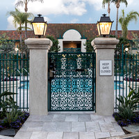 _M2_2955-remove stains on both gate columns ,remove hotel behind red tile roof, keep all palm trees, replace white sky with clouds provided, remove blue cone left of gate